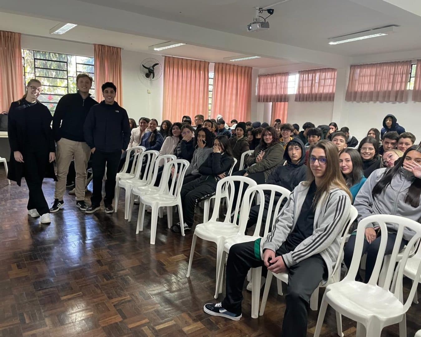 Membros da Liga diante de uma turma de ensino médio antes de uma palestra de educação financeira