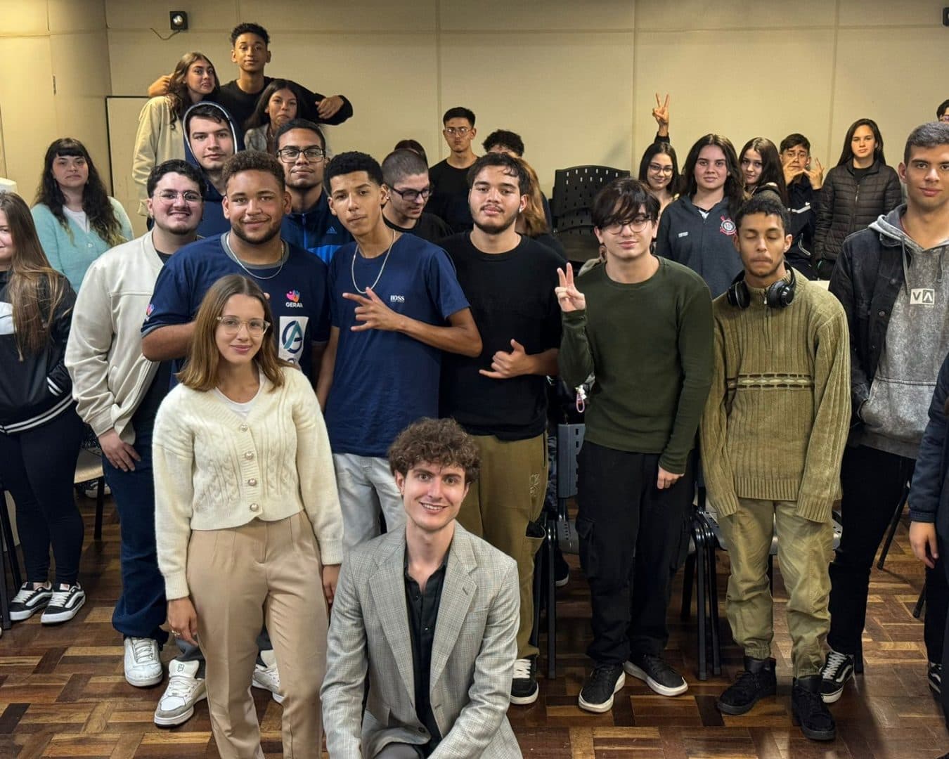 Estudantes de ensino médio posando com membros da Liga depois de uma palestra